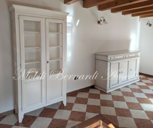 Vetrina in legno stile country con altri mobili da soggiorno e cucina nello stesso stile e finitura